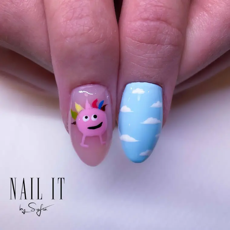 Nail art med karaktärsdesign mot himmelsblå bakgrund